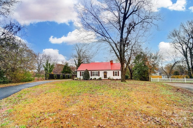 cape cod house featuring a front lawn