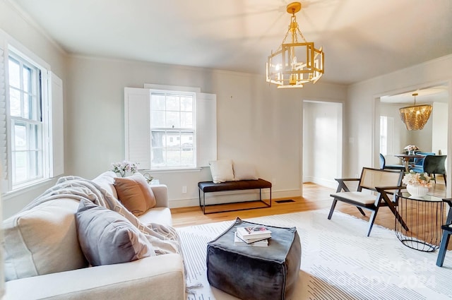 living room with a chandelier, hardwood / wood-style floors, and ornamental molding