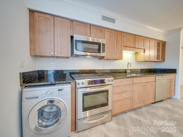 kitchen featuring visible vents, dark stone counters, glass insert cabinets, washer / clothes dryer, and stainless steel appliances