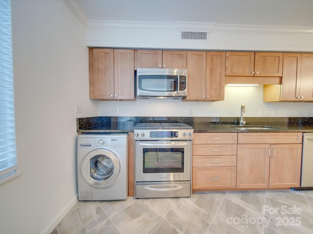 kitchen featuring a sink, visible vents, appliances with stainless steel finishes, washer / clothes dryer, and crown molding