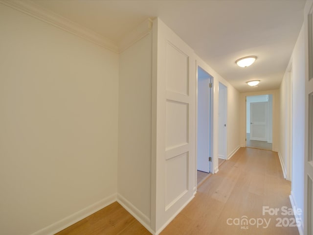 hall featuring baseboards and light wood finished floors