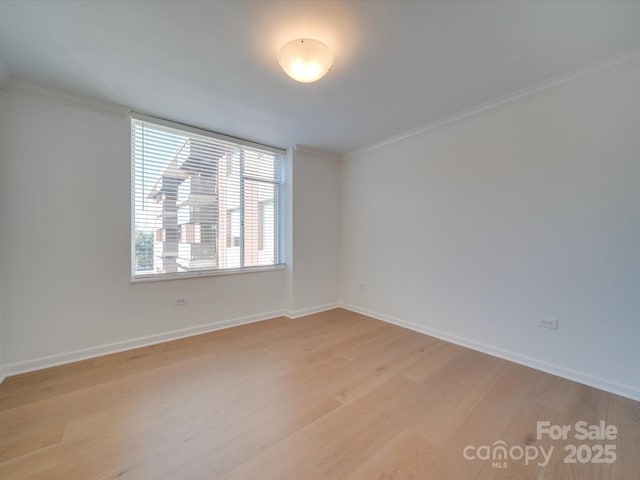 unfurnished room with light wood finished floors, baseboards, and ornamental molding