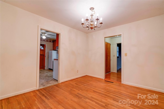 unfurnished room with a chandelier and wood-type flooring