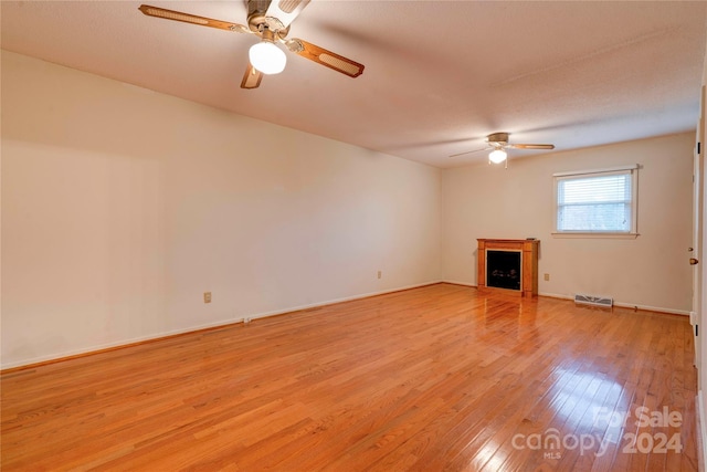 unfurnished living room featuring ceiling fan, a textured ceiling, and light wood-type flooring