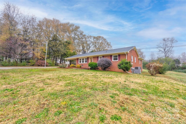 ranch-style house with a front lawn and cooling unit