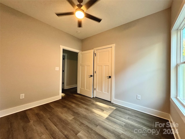 unfurnished bedroom featuring dark hardwood / wood-style flooring and ceiling fan