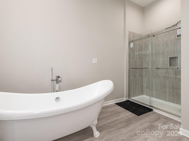 bathroom with hardwood / wood-style flooring and independent shower and bath