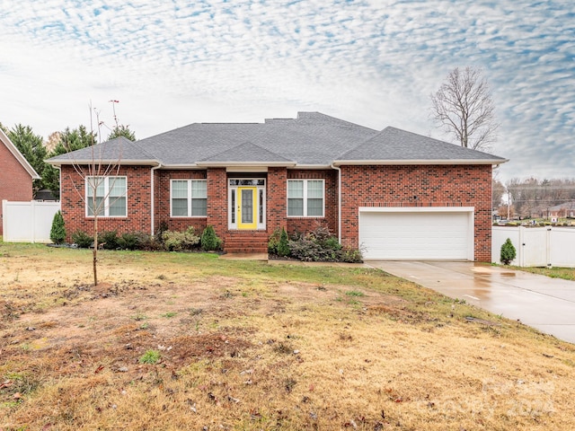 single story home with a garage and a front lawn