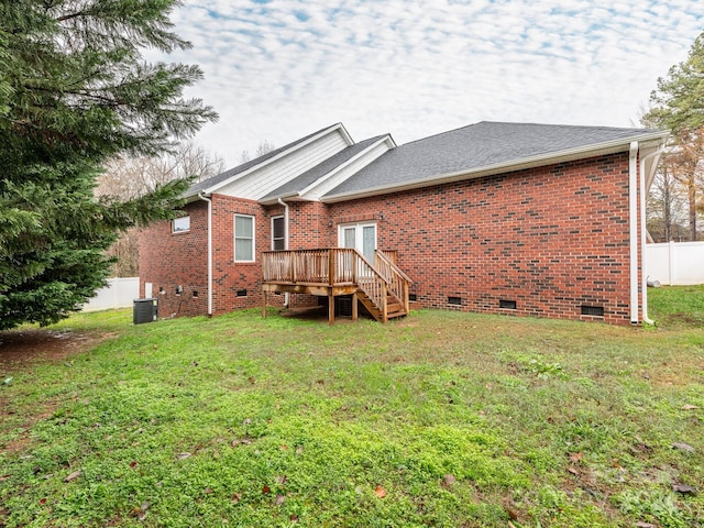 rear view of house featuring central air condition unit, a deck, and a lawn