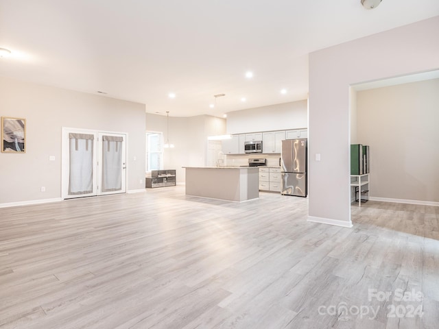 unfurnished living room with light hardwood / wood-style floors and sink