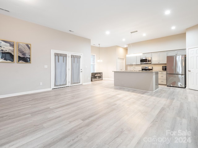 unfurnished living room with light hardwood / wood-style floors and sink