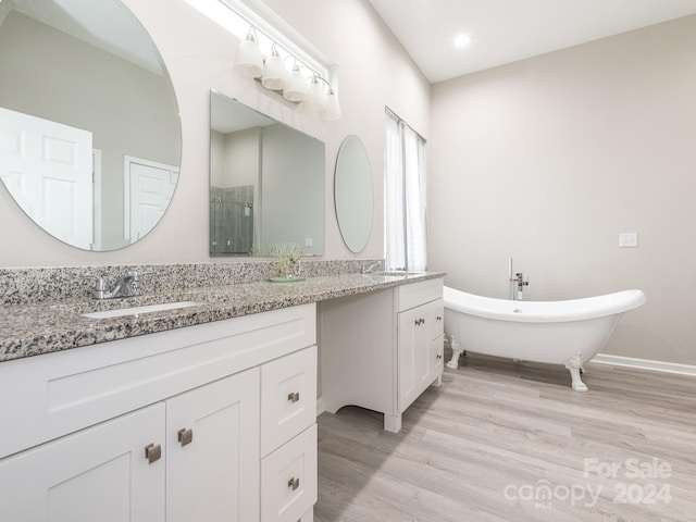 bathroom with hardwood / wood-style floors, vanity, and separate shower and tub