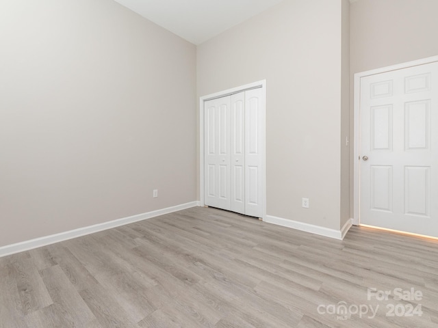 unfurnished bedroom with light hardwood / wood-style flooring and a closet