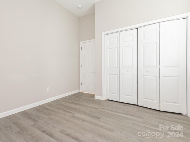 unfurnished bedroom featuring light hardwood / wood-style flooring and a closet