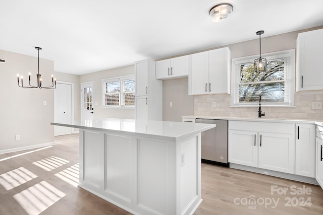 kitchen with white cabinets, stainless steel dishwasher, a wealth of natural light, and sink