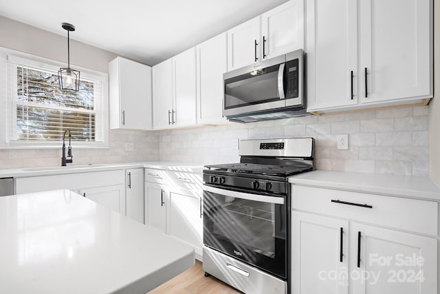 kitchen featuring white cabinets, light hardwood / wood-style floors, sink, and appliances with stainless steel finishes