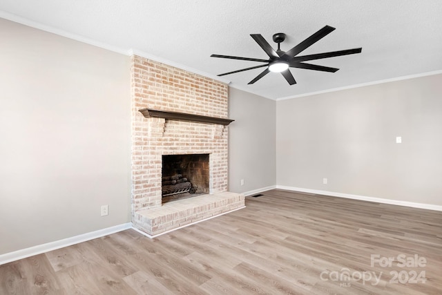 unfurnished living room with a brick fireplace, crown molding, a textured ceiling, and light hardwood / wood-style flooring