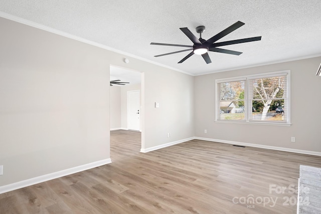 spare room featuring ceiling fan, crown molding, light wood-type flooring, and a textured ceiling