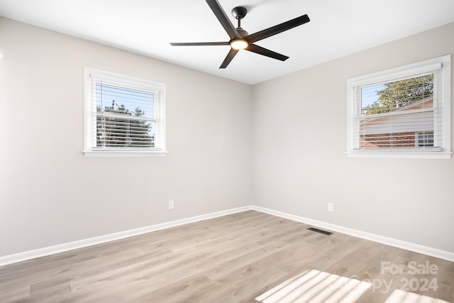 spare room with ceiling fan and light wood-type flooring