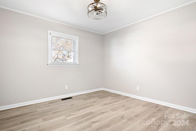 spare room with crown molding and light hardwood / wood-style floors