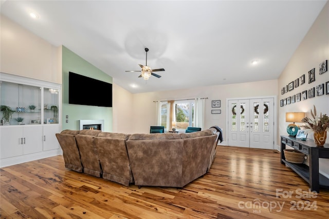 living room featuring hardwood / wood-style flooring, ceiling fan, and high vaulted ceiling