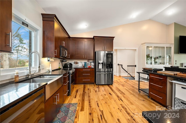 kitchen with sink, light hardwood / wood-style flooring, vaulted ceiling, dark brown cabinets, and appliances with stainless steel finishes