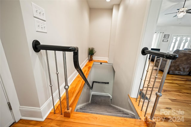 stairs with ceiling fan and wood-type flooring