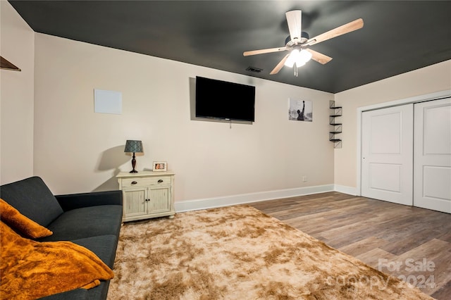 sitting room with ceiling fan and wood-type flooring