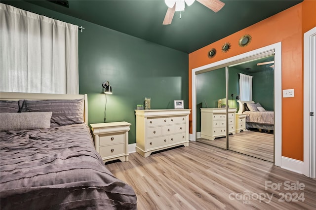 bedroom featuring ceiling fan, a closet, light hardwood / wood-style floors, and vaulted ceiling