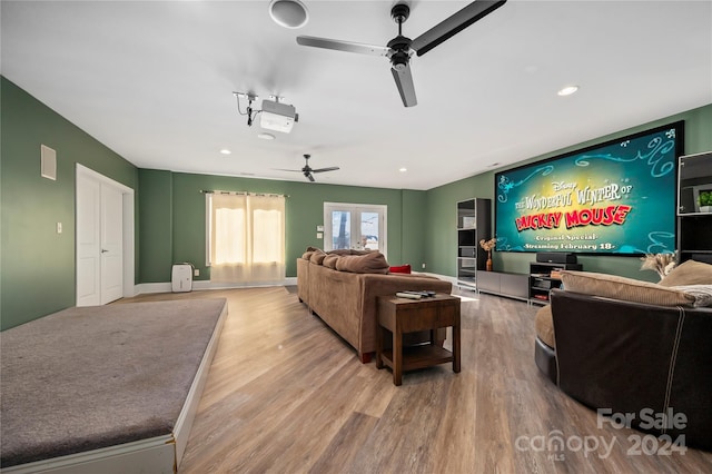 cinema room featuring hardwood / wood-style flooring and ceiling fan