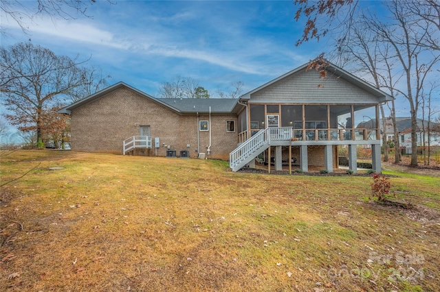 back of house with a sunroom, central air condition unit, and a lawn