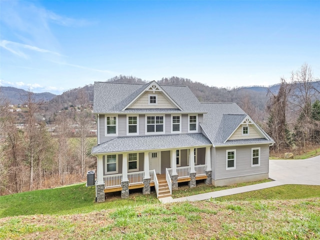 view of front of home with a mountain view, a front lawn, and a porch