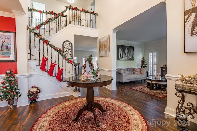 foyer entrance with crown molding and dark wood-type flooring