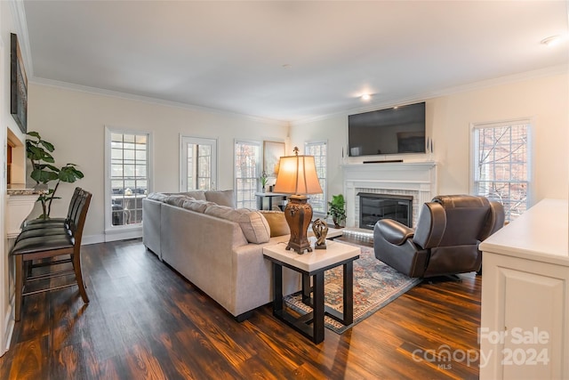 living room featuring dark hardwood / wood-style floors, ornamental molding, and a brick fireplace