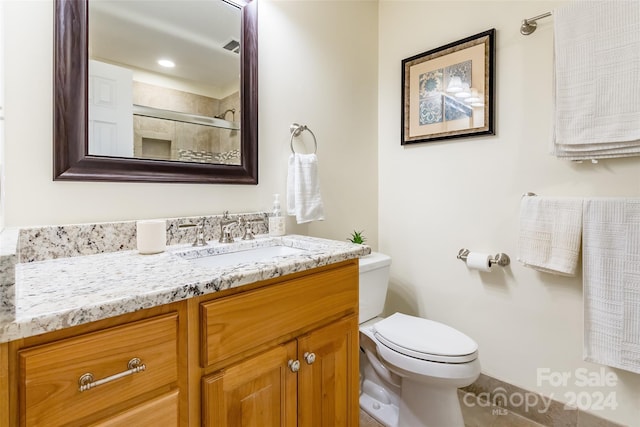 bathroom with a shower, tile patterned flooring, vanity, and toilet