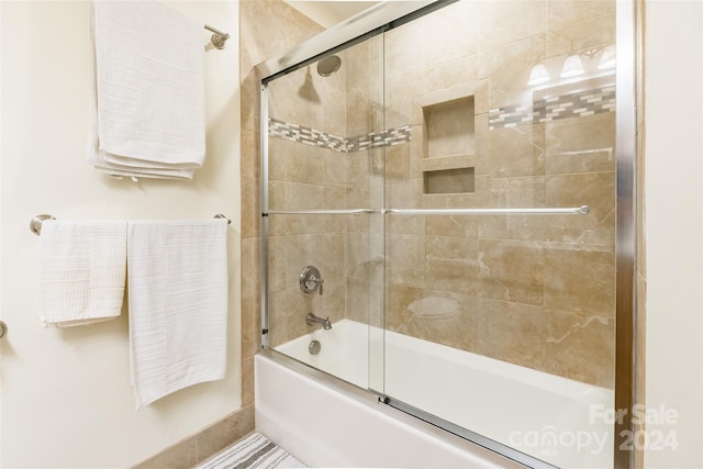 bathroom featuring combined bath / shower with glass door