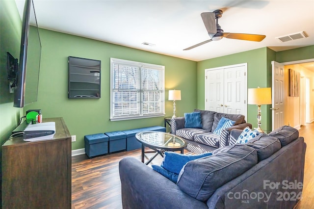 living room with ceiling fan and dark wood-type flooring