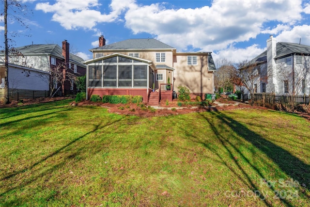 back of property with a lawn and a sunroom