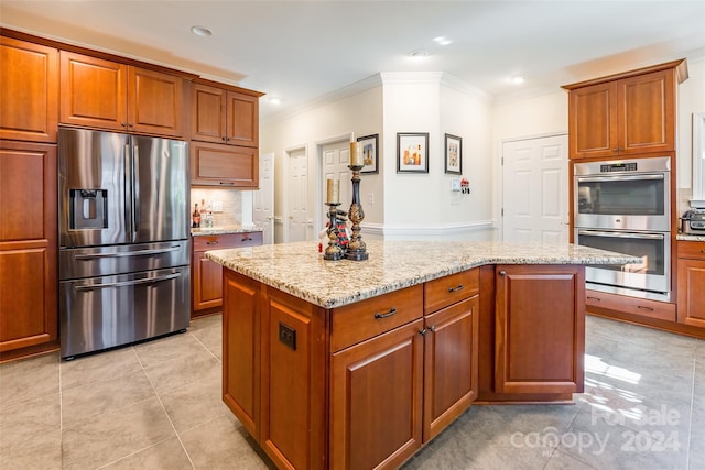 kitchen featuring light stone counters, a center island, light tile patterned flooring, and stainless steel appliances