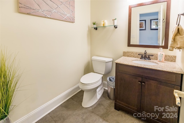 bathroom with tile patterned flooring, vanity, and toilet