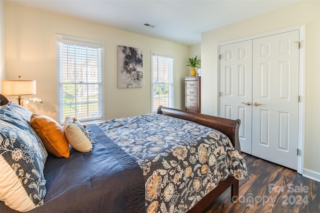 bedroom with dark wood-type flooring and a closet