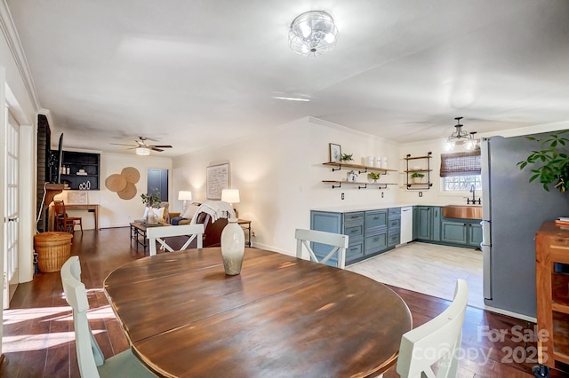 dining space featuring light hardwood / wood-style floors, ceiling fan, ornamental molding, and sink