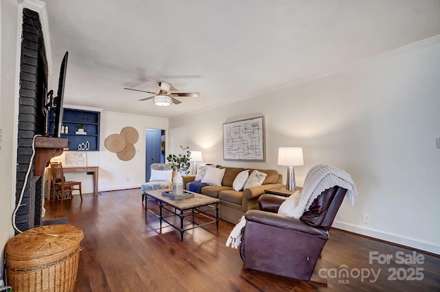 living room featuring a fireplace, dark hardwood / wood-style floors, ceiling fan, and ornamental molding