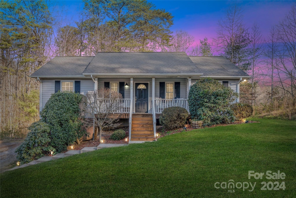 single story home with a lawn and covered porch