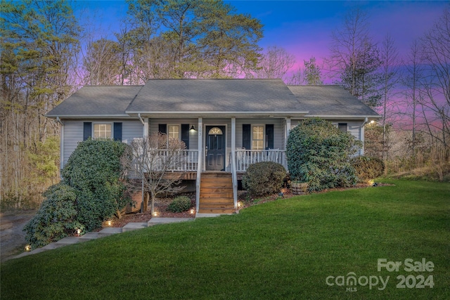 single story home with a lawn and covered porch