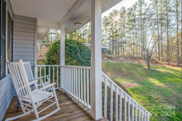 deck featuring covered porch and a lawn