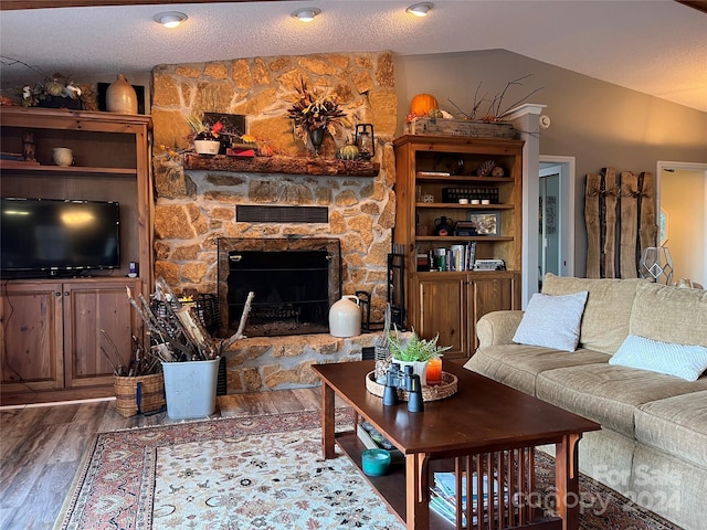 living room with a textured ceiling, a fireplace, hardwood / wood-style floors, and lofted ceiling