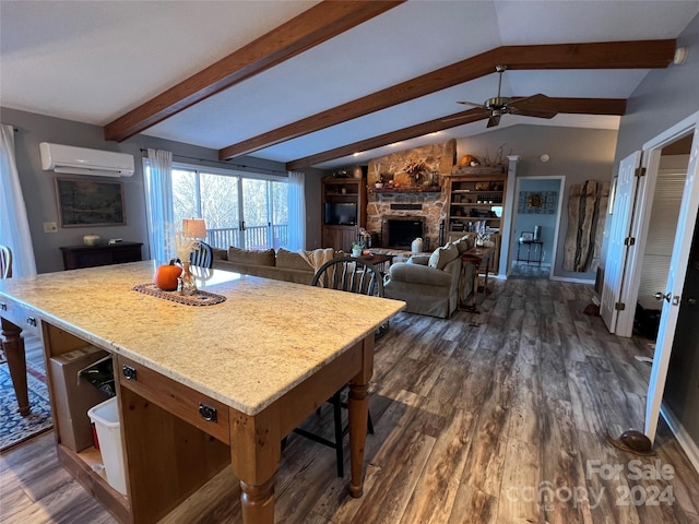 kitchen featuring a breakfast bar, lofted ceiling with beams, an AC wall unit, dark hardwood / wood-style floors, and a fireplace