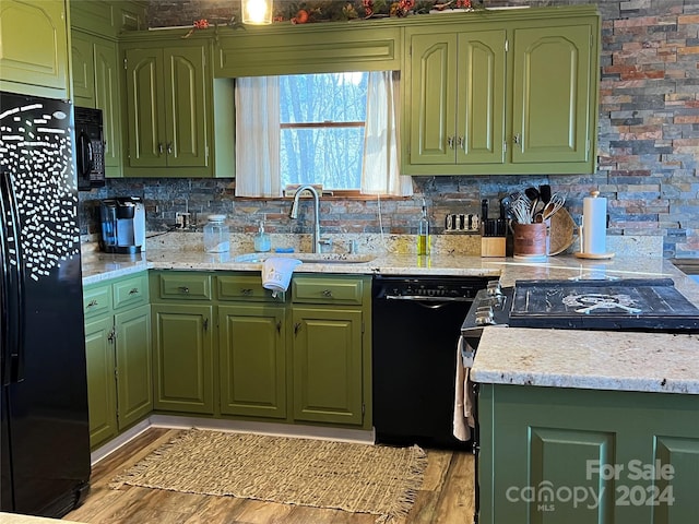 kitchen featuring black appliances, light hardwood / wood-style floors, sink, and tasteful backsplash