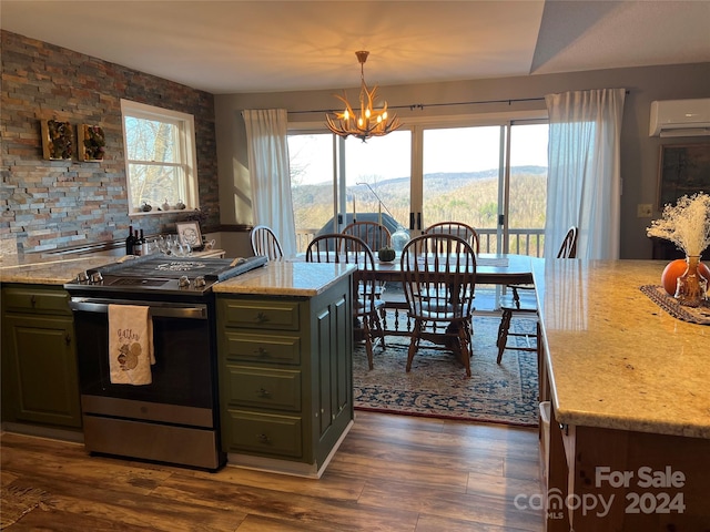 kitchen with dark hardwood / wood-style flooring, stainless steel range oven, an AC wall unit, a mountain view, and pendant lighting